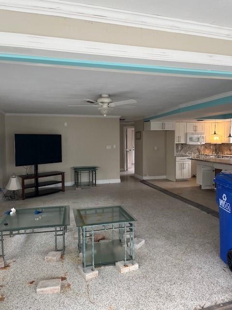 living room with ornamental molding and ceiling fan