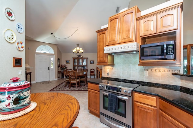 kitchen with appliances with stainless steel finishes, hanging light fixtures, tasteful backsplash, a notable chandelier, and vaulted ceiling