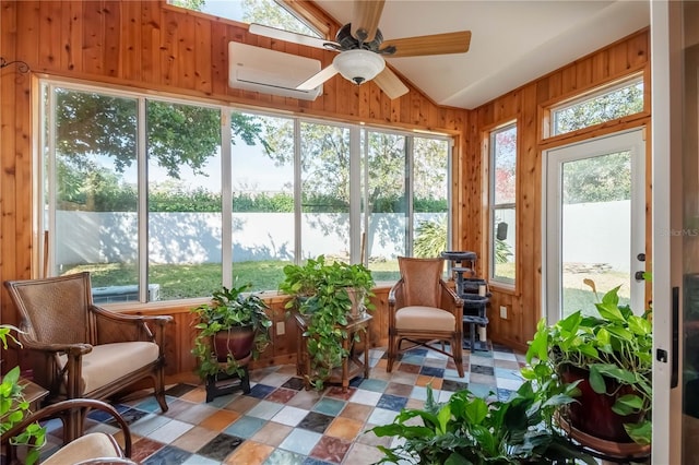 sunroom / solarium with plenty of natural light, a wall unit AC, and vaulted ceiling