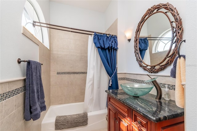 bathroom featuring shower / bath combo, tile walls, and vanity