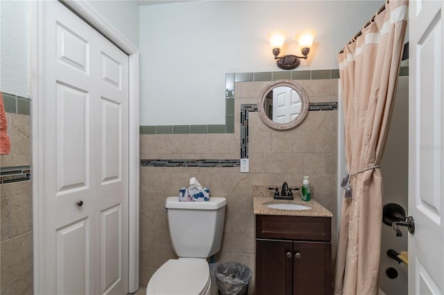 bathroom with vanity, curtained shower, toilet, and tile walls