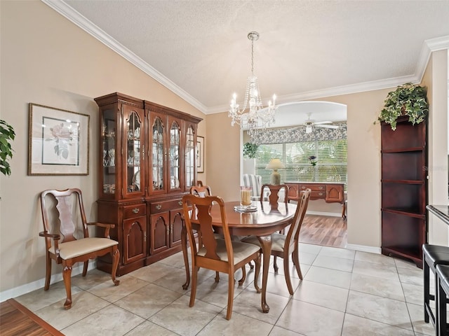 dining room with vaulted ceiling, ceiling fan with notable chandelier, light tile patterned floors, and ornamental molding