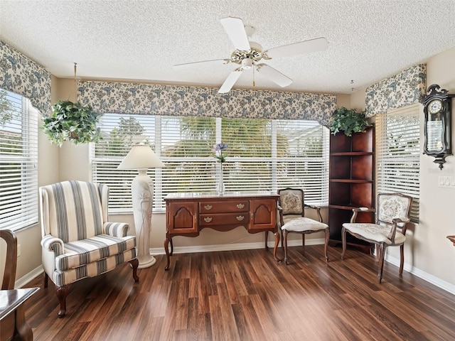 living area with ceiling fan, a textured ceiling, and dark hardwood / wood-style flooring