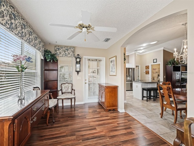 sitting room with ceiling fan with notable chandelier, hardwood / wood-style floors, crown molding, and a textured ceiling