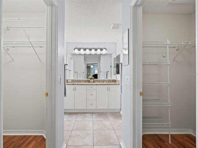 bathroom with vanity, a textured ceiling, and hardwood / wood-style flooring