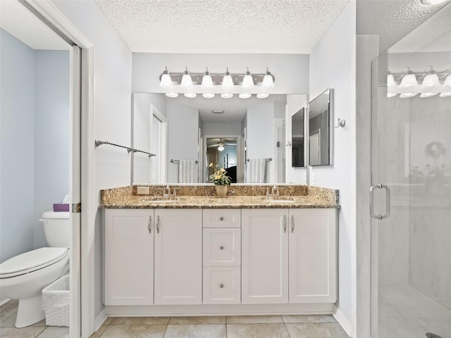 bathroom with toilet, a shower with shower door, tile patterned floors, a textured ceiling, and vanity