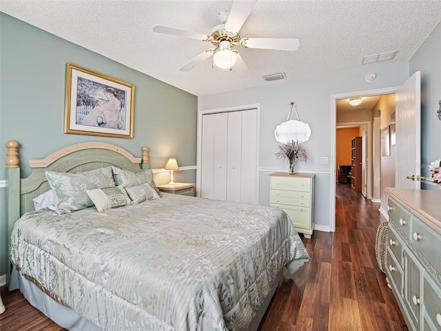 bedroom featuring ceiling fan, a closet, dark hardwood / wood-style flooring, and a textured ceiling