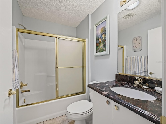 full bathroom with toilet, bath / shower combo with glass door, vanity, tile patterned floors, and a textured ceiling