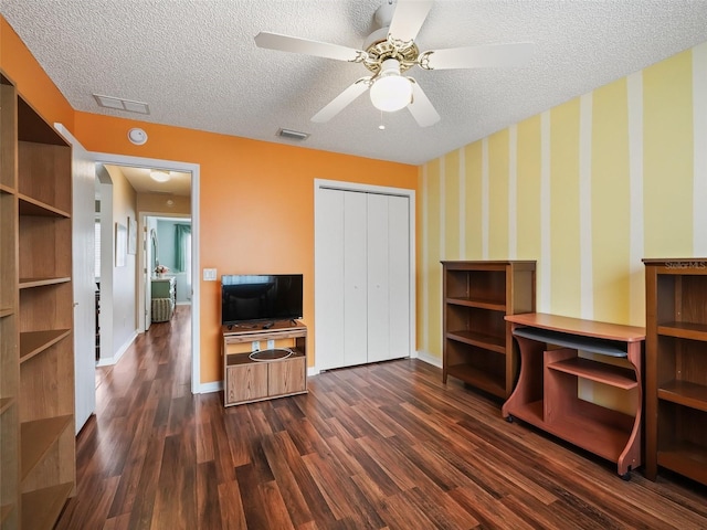 interior space with ceiling fan, dark hardwood / wood-style flooring, and a textured ceiling