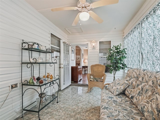 living room featuring ceiling fan and wood walls