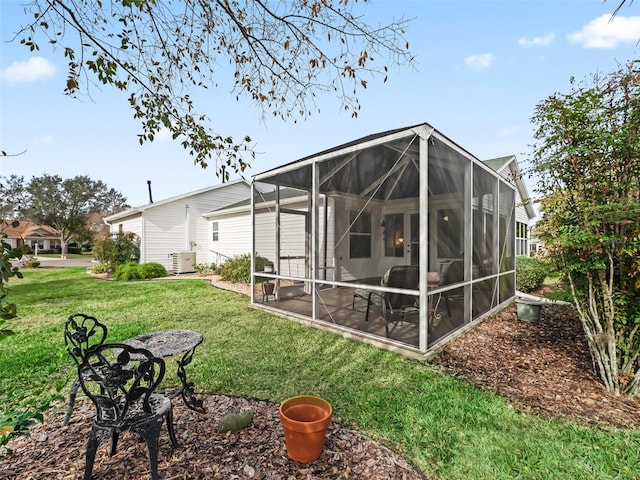 rear view of house with cooling unit and a yard