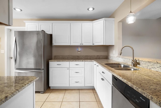 kitchen featuring light stone counters, stainless steel appliances, sink, white cabinets, and hanging light fixtures