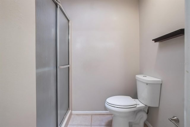 bathroom featuring tile patterned floors, a shower with shower door, and toilet