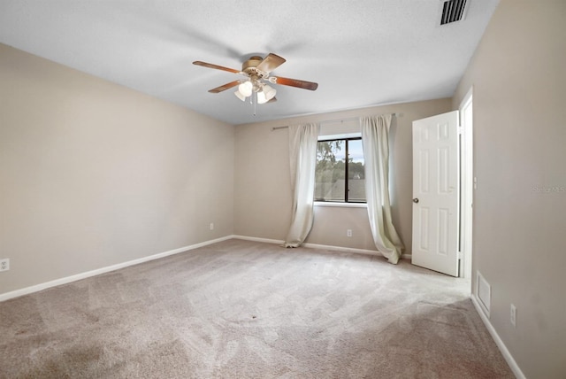 carpeted spare room featuring ceiling fan