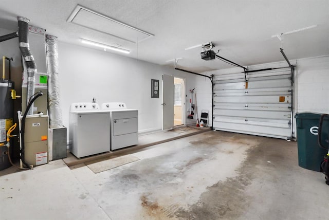 garage with washing machine and dryer, a garage door opener, and water heater