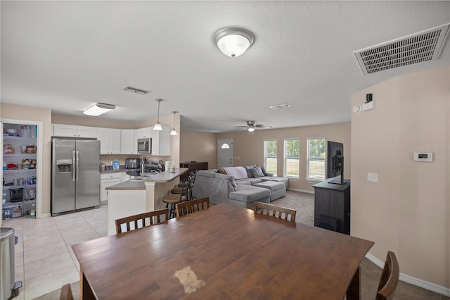 dining room featuring ceiling fan, sink, and light tile patterned floors