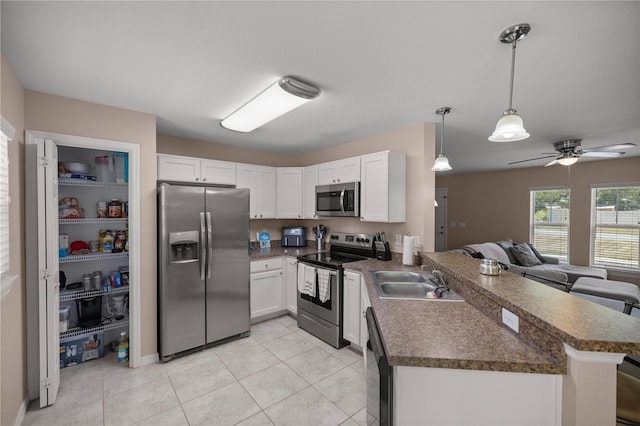 kitchen with kitchen peninsula, sink, white cabinets, and appliances with stainless steel finishes