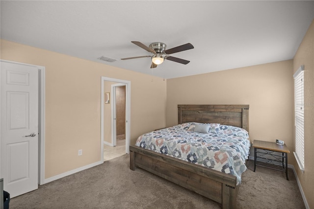 carpeted bedroom featuring ceiling fan and ensuite bath