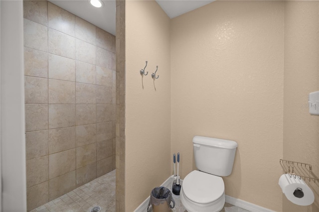 bathroom featuring tiled shower and toilet