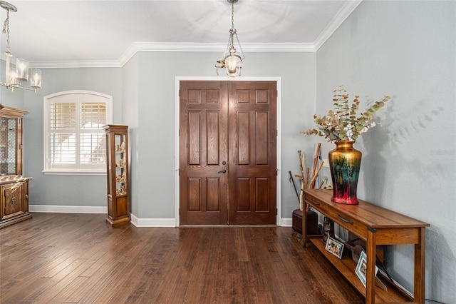 entrance foyer with dark hardwood / wood-style floors, crown molding, and a notable chandelier