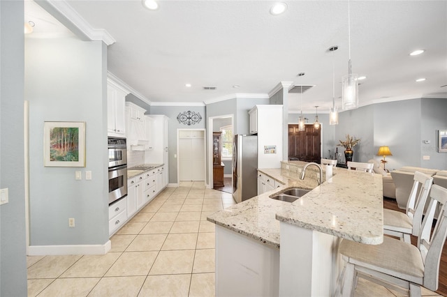 kitchen featuring kitchen peninsula, pendant lighting, sink, a breakfast bar area, and stainless steel appliances