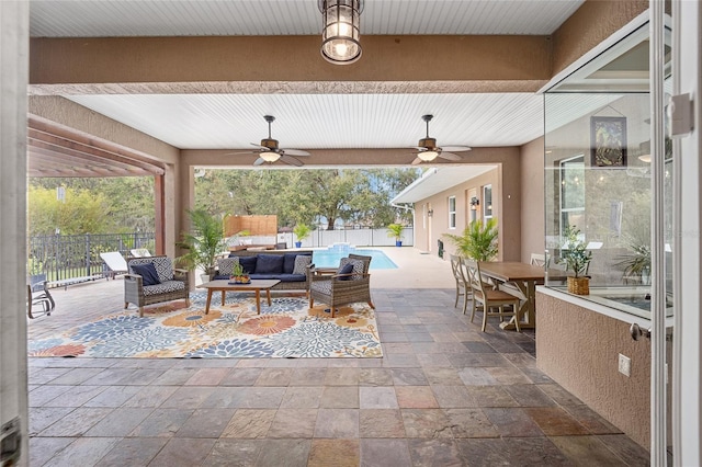 view of patio with an outdoor living space, a fenced in pool, and ceiling fan