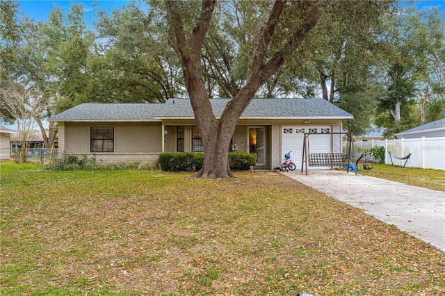 single story home with a garage and a front lawn