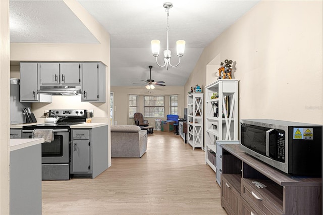 kitchen with vaulted ceiling, decorative light fixtures, gray cabinets, ceiling fan with notable chandelier, and appliances with stainless steel finishes