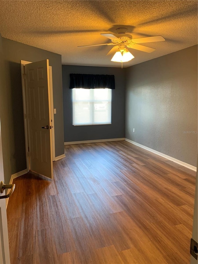 unfurnished room with ceiling fan, hardwood / wood-style floors, and a textured ceiling