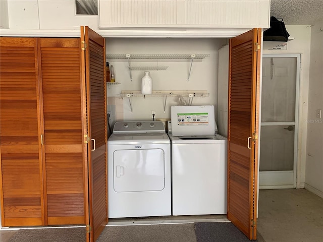 laundry room featuring washing machine and clothes dryer and a textured ceiling