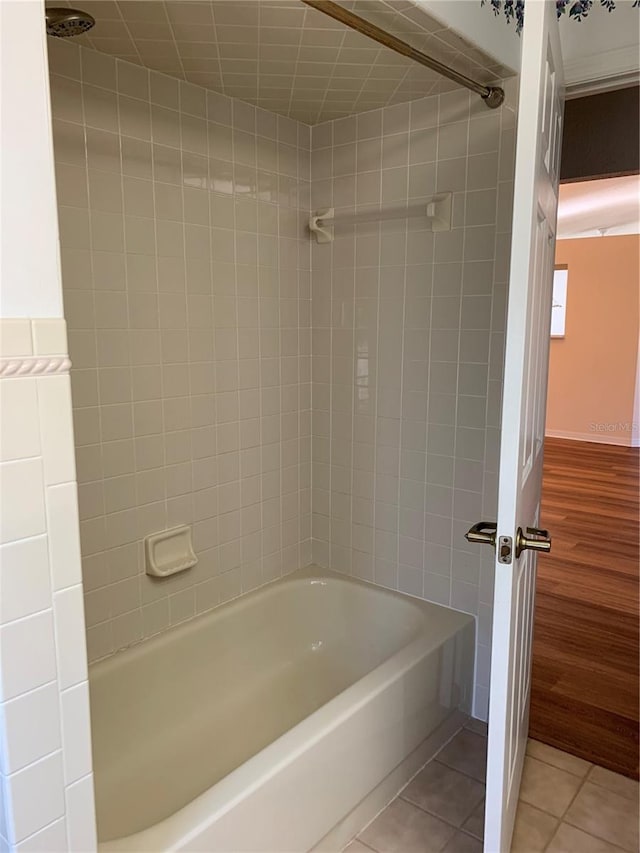 bathroom featuring tiled shower / bath combo and tile patterned flooring