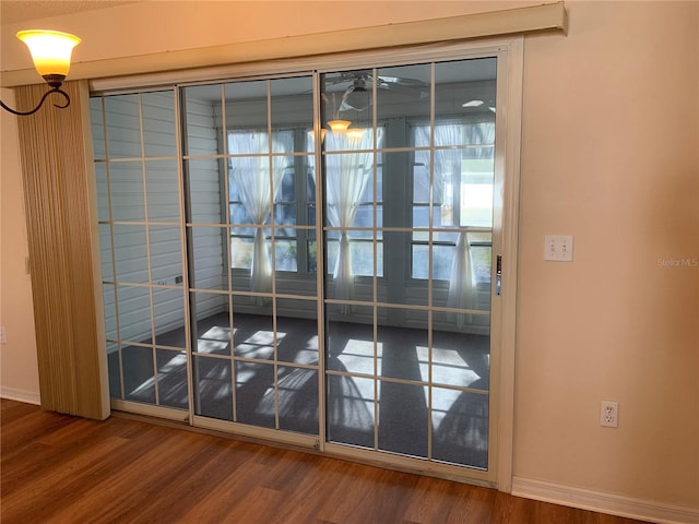 doorway with ceiling fan and wood-type flooring