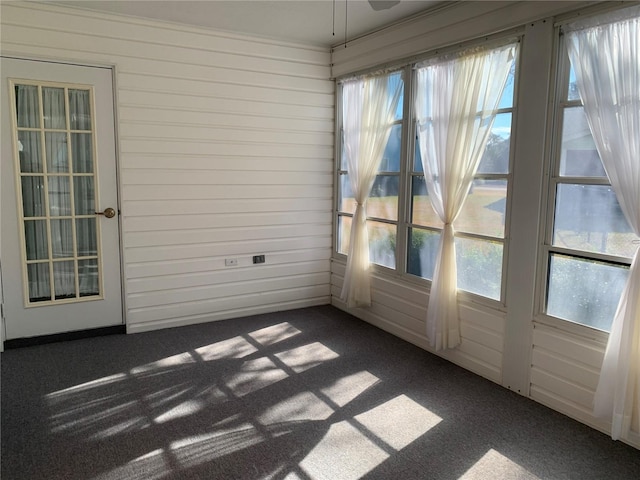 unfurnished sunroom featuring ceiling fan