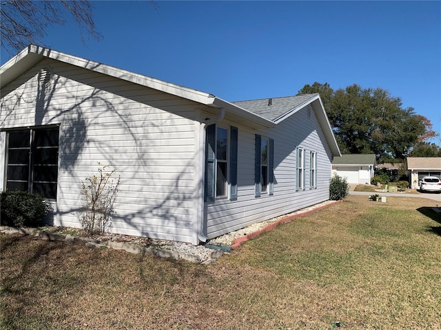 view of side of home featuring a garage and a yard