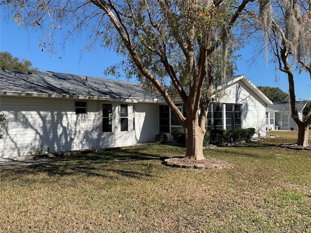 view of side of home with a yard