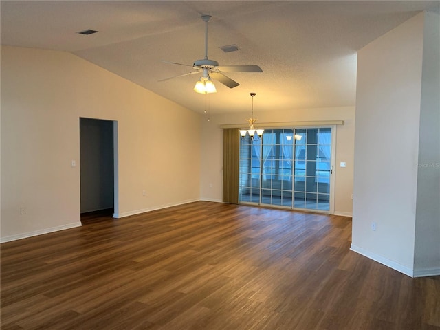 spare room with ceiling fan with notable chandelier, dark hardwood / wood-style floors, and vaulted ceiling