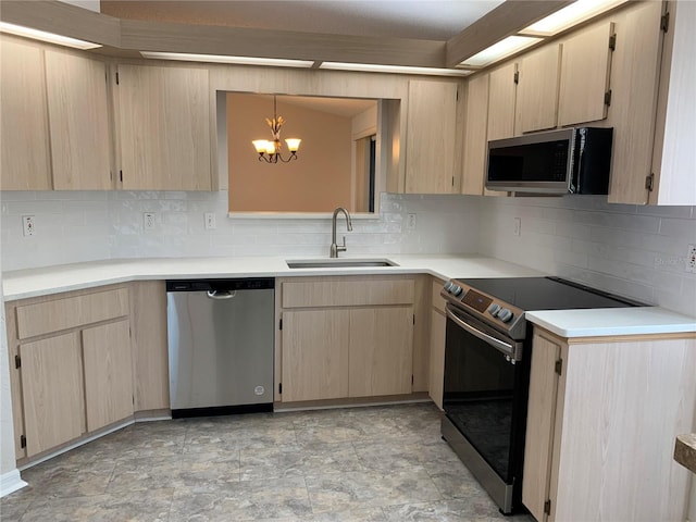 kitchen featuring light brown cabinetry, appliances with stainless steel finishes, sink, and pendant lighting