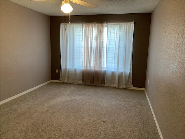 unfurnished room with ceiling fan, a textured ceiling, and carpet flooring