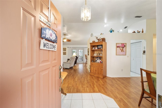 foyer featuring ceiling fan, french doors, light wood-type flooring, and lofted ceiling