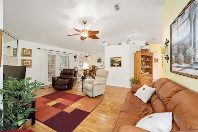 living room featuring vaulted ceiling, ceiling fan, and hardwood / wood-style flooring