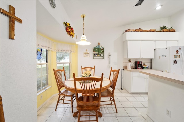 tiled dining space featuring lofted ceiling