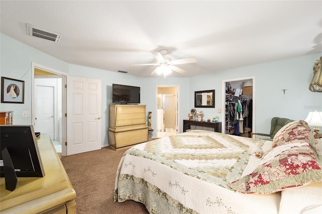 carpeted bedroom with ceiling fan, a spacious closet, connected bathroom, and a closet