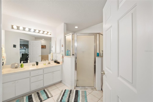 bathroom featuring vanity, tile patterned floors, a shower with shower door, and a textured ceiling