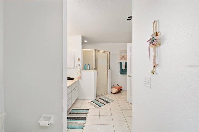 bathroom with an enclosed shower, tile patterned floors, and vanity