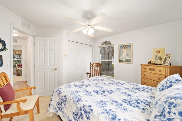 carpeted bedroom featuring ceiling fan, a closet, and multiple windows