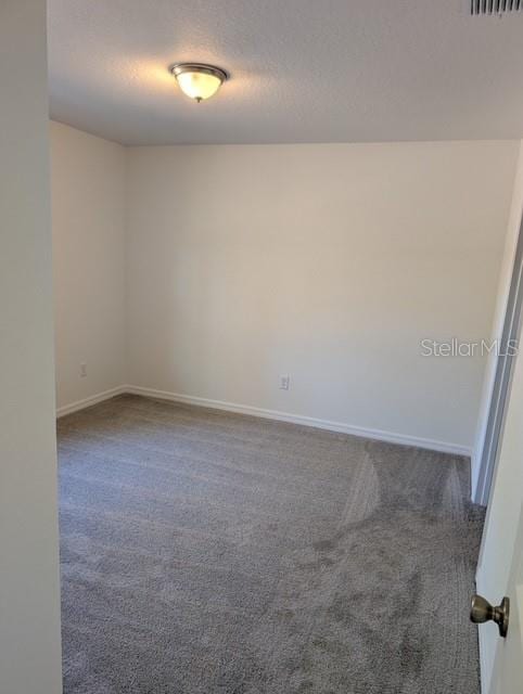 carpeted spare room with a textured ceiling