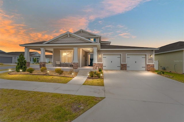 view of front facade featuring a porch, a garage, and a yard