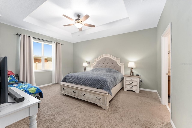 bedroom with light carpet, a raised ceiling, and ceiling fan