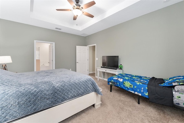 carpeted bedroom with a tray ceiling and ceiling fan