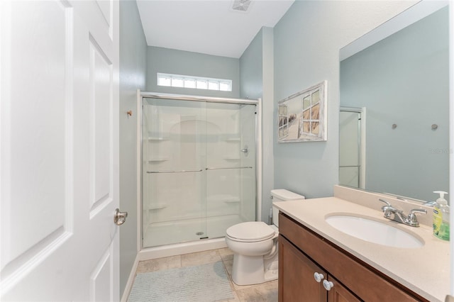 bathroom featuring tile patterned floors, vanity, toilet, and a shower with shower door